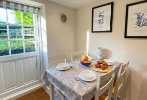 a dining room with a table and chairs and a window at Norfolk Chapel Cottages in Docking