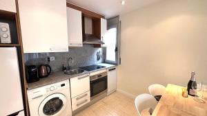 a kitchen with a sink and a washing machine at Dúplex ático familiar by Prestigi in Terrassa