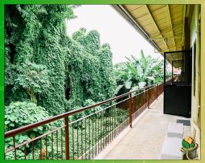 einen Balkon mit einem Zaun und Bäumen mit Bänken in der Unterkunft Homey 2BR Apartment with Essentials & Modern Decor - Richkizz in Puerto Princesa