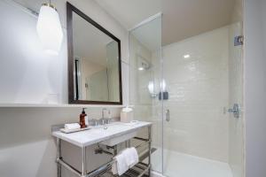 a bathroom with a sink and a shower with a mirror at The Alida, Savannah, a Tribute Portfolio Hotel in Savannah