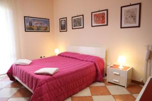 ピッツォにあるCentauro by PizzoApartmentsのベッドルーム1室(大型ピンクベッド1台、ランプ2つ付)
