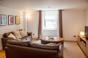 a living room with a couch and a table at CS Exclusive Apartments of Princess Street West End in Edinburgh +11 photos