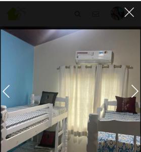 ein Schlafzimmer mit zwei Betten und einer Klimaanlage in der Unterkunft casa da maria in Cabo Frio