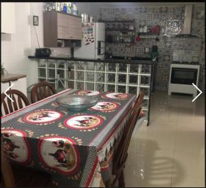 eine Küche mit einem Tisch mit einer Tischdecke darauf in der Unterkunft casa da maria in Cabo Frio