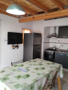 una cocina con una mesa y un refrigerador en Departamentos Caracol, en Las Grutas