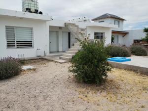Una casa blanca con escaleras al frente. en Departamentos Caracol, en Las Grutas