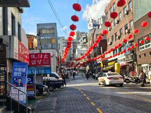 a street with red lanterns on a city street at Busan Subway 6min #2 Rooms #2 Queen Beds #Hotel Bedding #OTT #Table#1st Floor in Busan