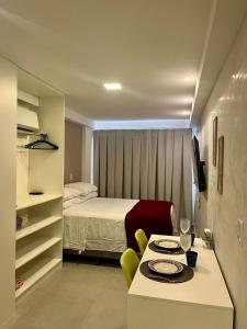 Habitación pequeña con cama y mesa con sillas. en Cupe Porto de Galinhas - Cupe Exclusive 407, en Porto de Galinhas