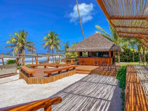 ein Pavillon mit Bänken und Tischen am Strand in der Unterkunft Enotel Porto de Galinhas All Inclusive in Porto De Galinhas