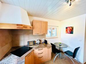 a kitchen with a table and a small table and chairs at Appartement duplex spacieux in Fleurier