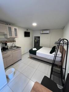 a small room with a bed and a kitchen at CASA HOTEL FLOR DEL VALLE in Cali