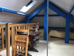 Pokój z niebieskimi ścianami, stołem i krzesłami w obiekcie Maison à Saint Briac sur Mer w mieście Saint-Briac-sur-Mer