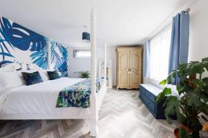 a bedroom with a white bed and a blue and white wall at Cosy Cabin Retreat Close to Beaches in Birdham