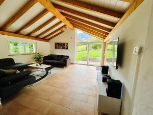a living room with a couch and a tv at Appartement duplex spacieux in Fleurier