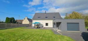 Biały dom z garażem na dziedzińcu w obiekcie Kokana modern holiday home w mieście Englesqueville-la-Percée