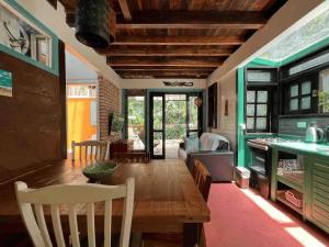 a dining room with a wooden table and chairs at Casa Saíra in Bombinhas