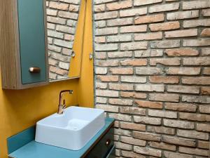 a bathroom with a sink and a brick wall at Casa Saíra in Bombinhas +27 photos