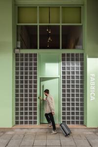 a person pulling a suitcase outside of a building at Fabrica PlayLoft in the City Center by BiNoBi! in Thessaloniki