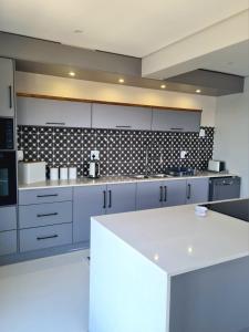 a kitchen with blue cabinets and a white counter top at Montagu Villa 3 in Mossel Bay