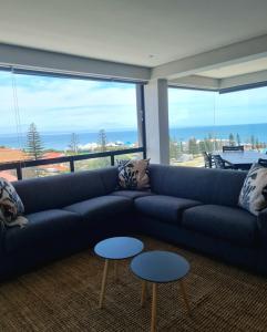 a living room with a blue couch and two tables at Montagu Villa 3 in Mossel Bay