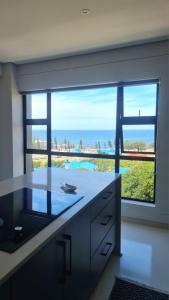 a kitchen with a large window with a view of the ocean at Montagu Villa 3 in Mossel Bay