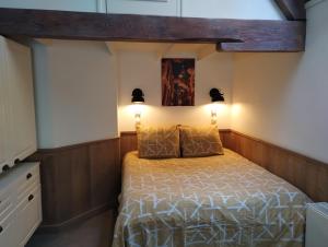 a bedroom with a bed and two lights on the wall at VRYE HEERLYKHEYD ( adults only ) studio 3 in Middelburg