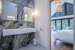 a bathroom with a sink next to a bedroom at Wisemans House Apartment 3 - Wisemans Bridge in Stepaside +69 photos