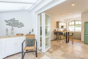 a kitchen with white cabinets and a table and chairs at Stadthaus im Kattsund Eckernförde zur Kurzzeitvermietung in Eckernförde +27 photos