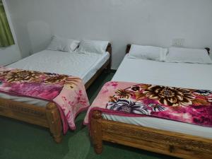 チクマガルールにあるLake Flower Homestayのベッド2台が備わる客室です。