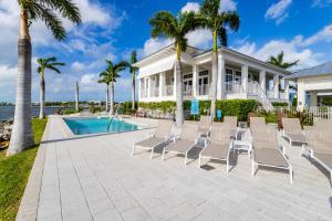 a house with chairs and a swimming pool at Twilight #32 in Key Largo