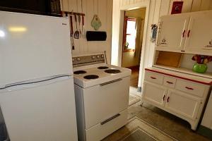 a kitchen with a white stove and a refrigerator at Lakeside Cottage on Torch Lake in Alden +32 photos