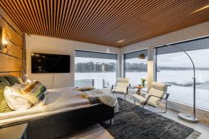 a bedroom with a large bed and a large window at Northern Lights River Nest in Rovaniemi