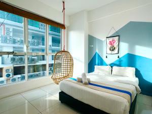 a bedroom with a bed and a hanging chair at Sunset Seaview Vacation Condos Infinity Avenue in Kota Kinabalu +107 photos