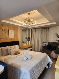 a bedroom with a large bed with towels on it at Side Wall Condo in San Fernando
