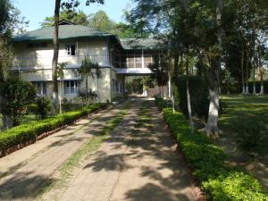 a house with a road in front of it at Chowkidinghee Heritage Tea Bungalow in Dibrugarh +25 photos