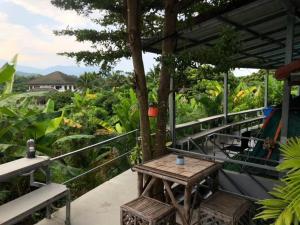 a table and chairs on the balcony of a house at Sandee camping by Sandee place mountain view hotel in Chom Thong