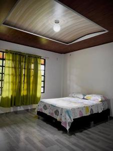 a bedroom with a bed in a room with green curtains at Cabaña Campestre in Buenavista