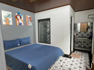 カットバ島にあるỐc Homestay Cát Bàの青いベッドと窓のある寝室