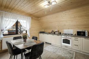 a kitchen with a table and chairs and a stove at Rusca Retreat in Ruşca
