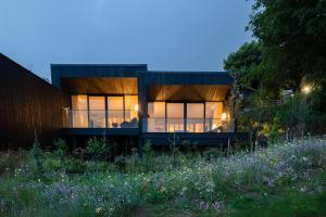 a house with glass windows in a field of flowers at The Woodland Suite Experience at the Montenotte in Cork +9 photos