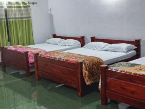 チクマガルールにあるLake Flower Homestayのツインベッド3台 緑のカーテンが備わる客室です。 +18枚の写真
