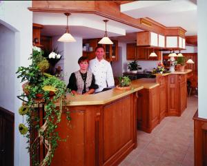 un hombre y una mujer parados en un mostrador de cocina en Hotel - Gasthof Spessarttor, en Lohr