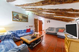 ein Wohnzimmer mit Sofas und einem Flachbildfernseher in der Unterkunft Cortijo El Álamo De Vélez in Vélez-Blanco