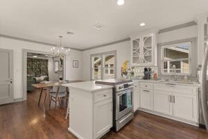 a kitchen with white cabinets and a dining room at Travelin On Tulsa Time-Near Expo, TU, Downtown in Tulsa