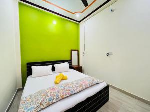 a bedroom with a bed with a green wall at Om Home Stay 3BHK in Ayodhya