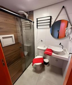 a bathroom with a toilet and a sink and a mirror at Pousada Impera - Campos do Jordão in Campos do Jordão