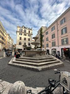 una fontana nel mezzo di una città con edifici di IMPERIAL suite COLOSSEUM a Roma