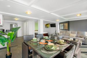 Una sala de estar con una mesa y sillas y un sofá. en The Wave House - Seaside Haven, en Jardim do Mar
