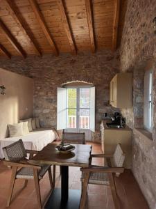 Una sala de estar con una mesa y una cama. en Balcony&Tower, en Areopoli