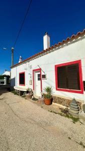 a white house with a red window and a door at Casa do Careca in Sagres
